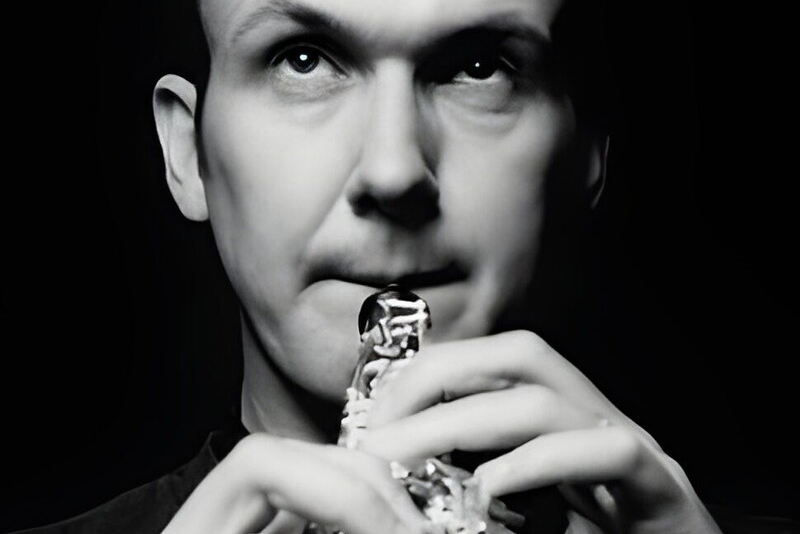 A black and white close up image of a man playing the oboe