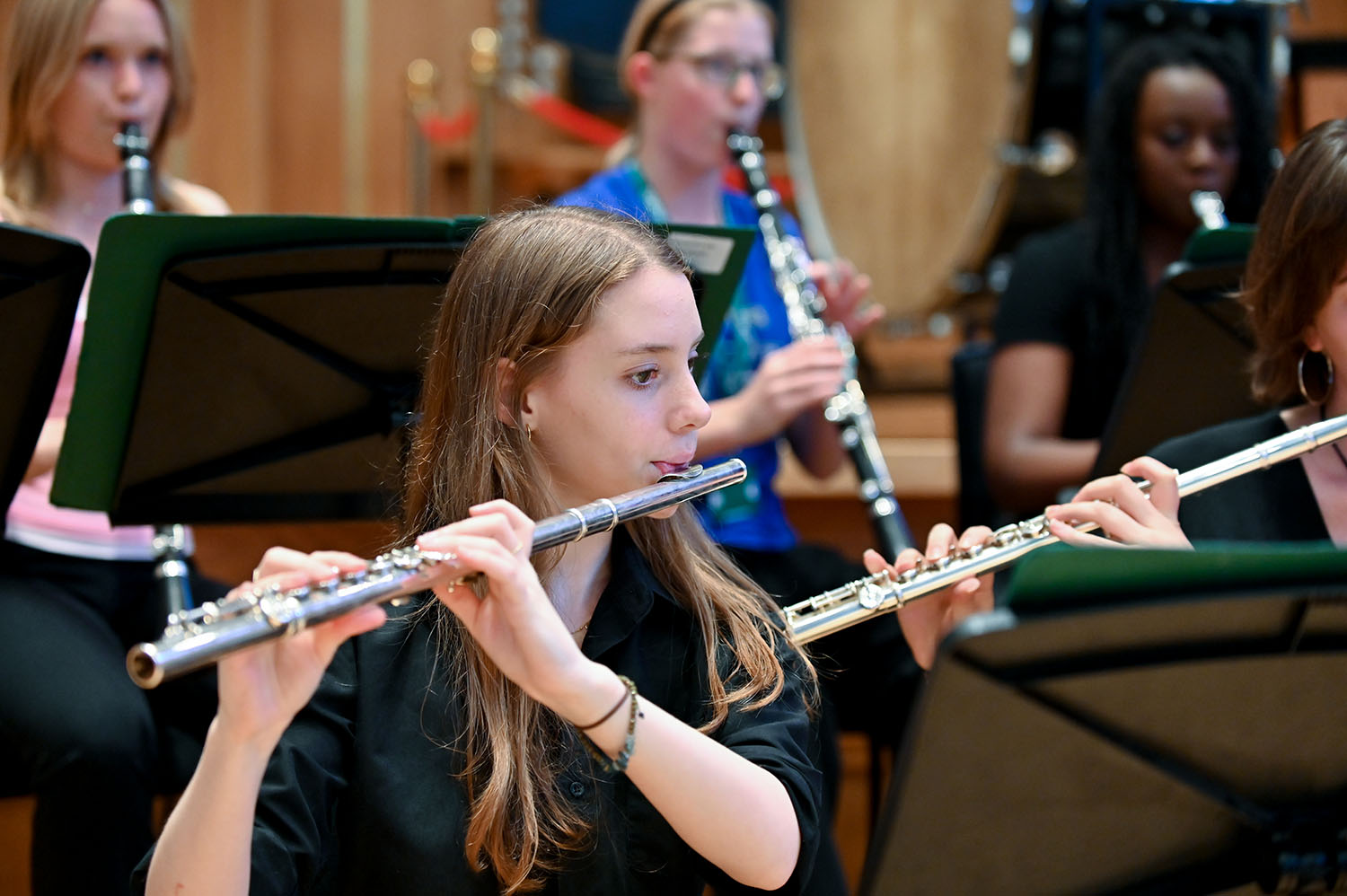 A JD student performing on the flute with clarinettists performing behind her